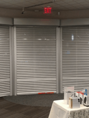 Security shutter style roll-up door installed in a curved bay window area
