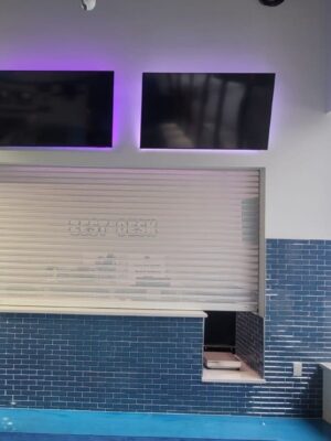 Security shutter style roll-up door installed near an exterior window
