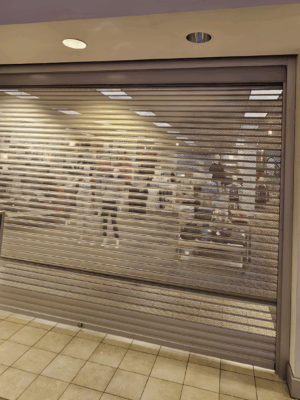 Security shutter style roll-up door installed to divide two shopping areas